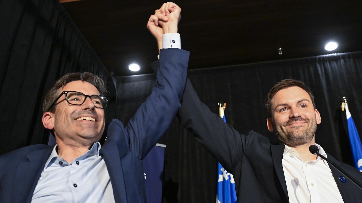 Le candidat Pascal Paradis lève son bras avec le chef du parti Paul St-Pierre Plamondon avant de prendre la parole devant les partisans.