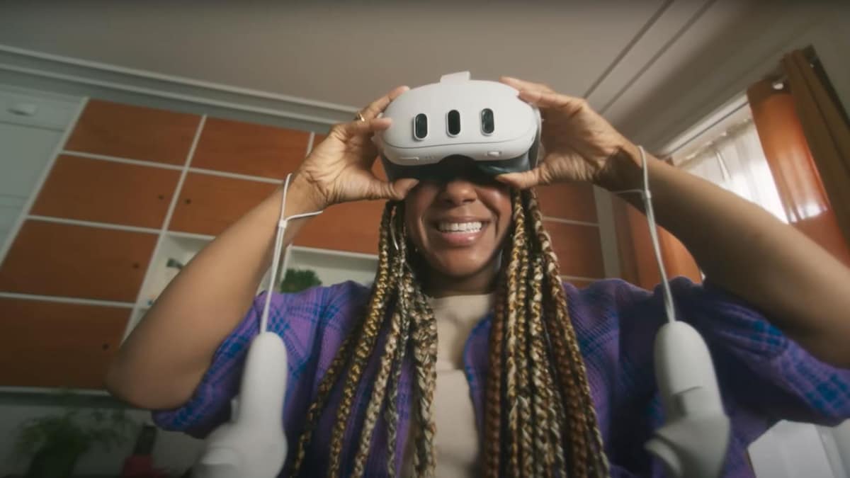 Une femme souriante avec un casque de réalité virtuelle sur la tête.