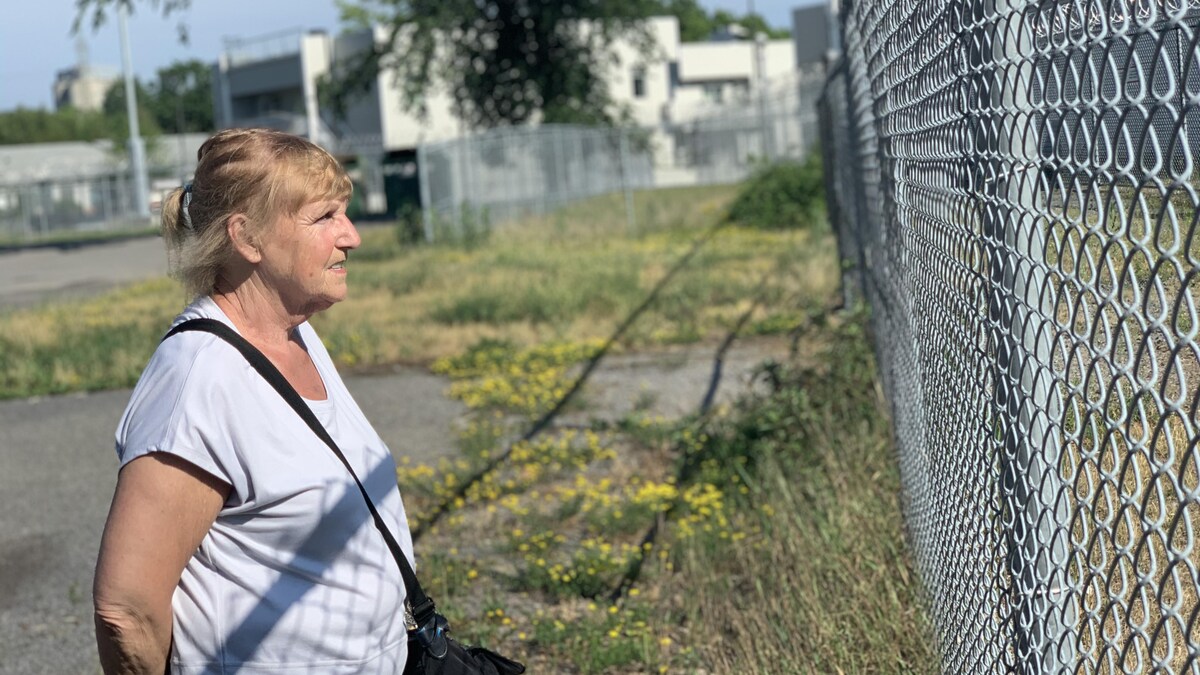 Pierrette Langevin se tient debout devant une clôture.