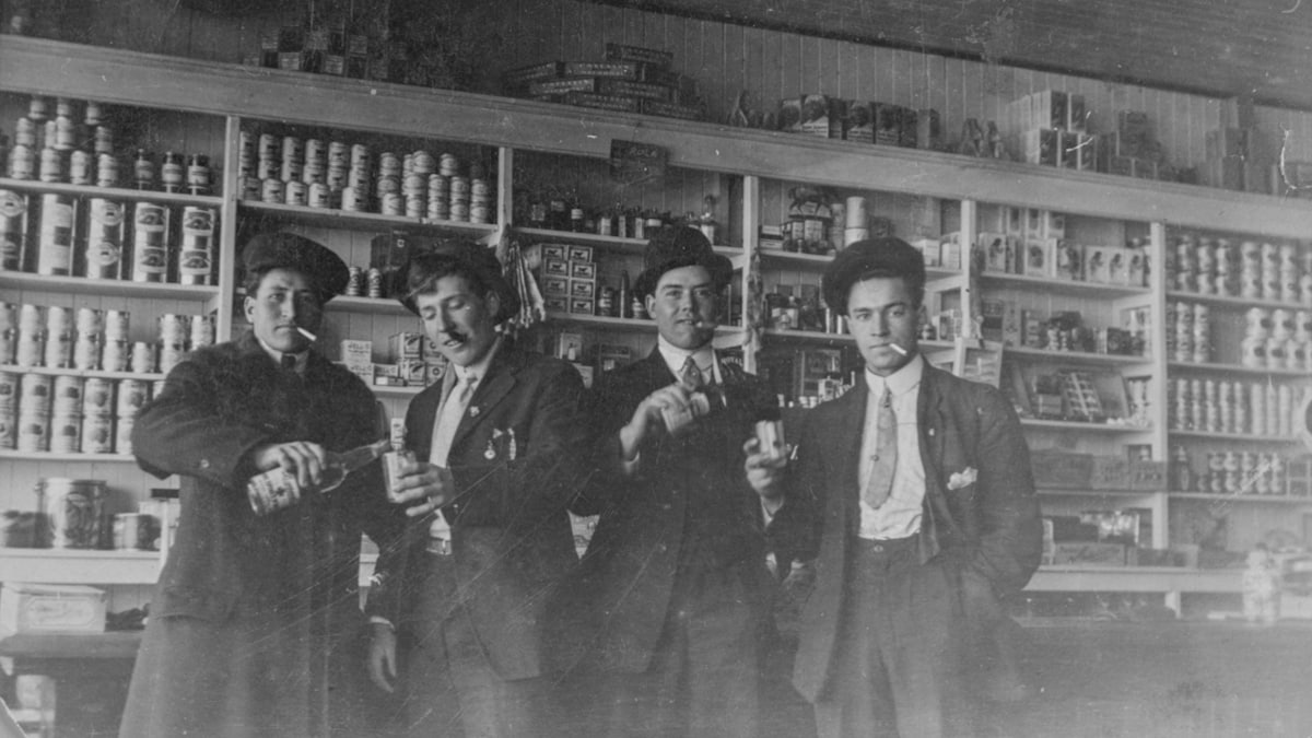 Alexander Bourassa, Frederick Plamondon, Arthur Bourassa et Benoit Plamondon buvant et fumant à l'intérieur du magasin Plamondon vers 1920. 