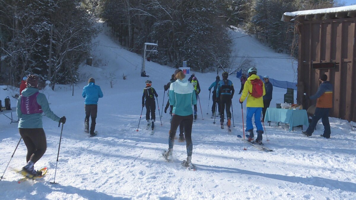 Des skieurs s'apprêtnt à monter une côte.