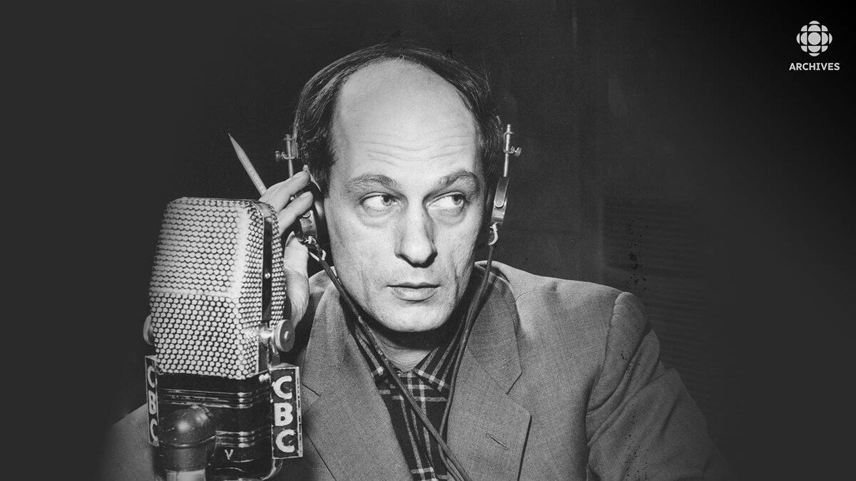 René Lévesque qui tient son écouteur derrière un micro de CBC.