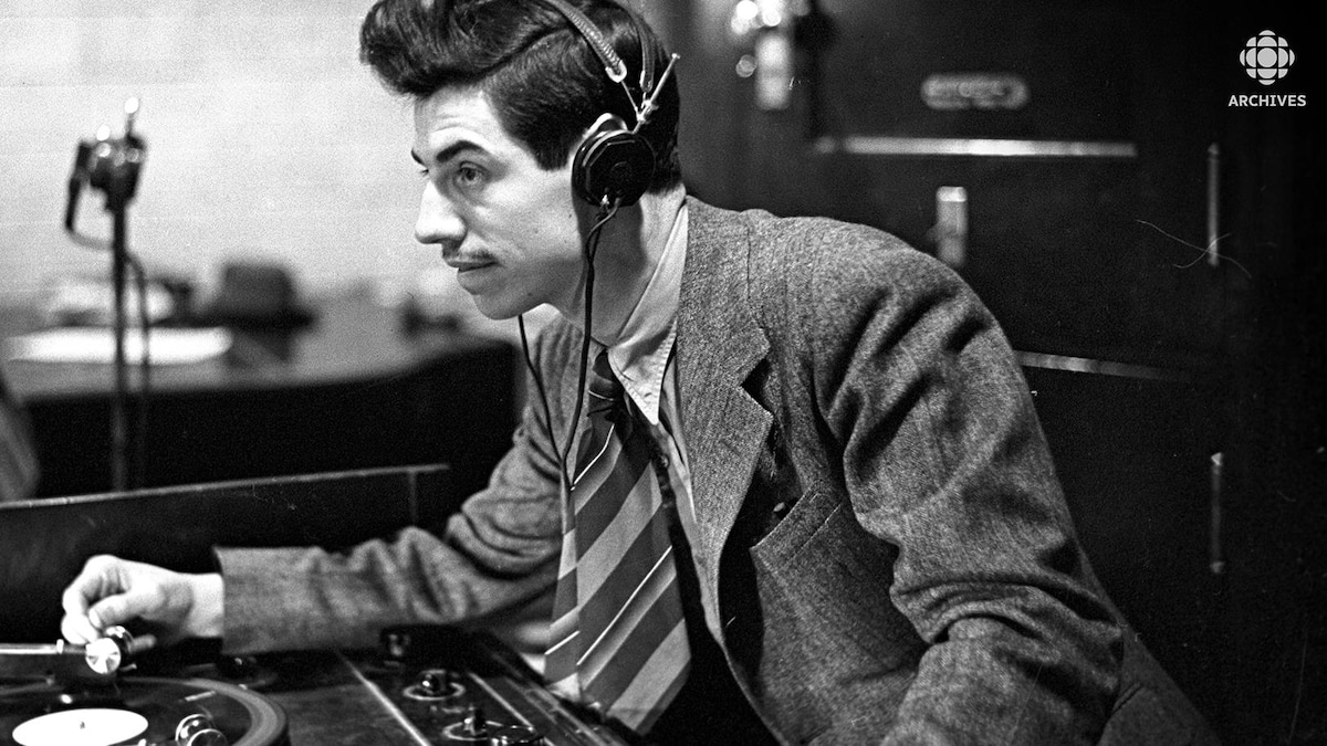Dans un studio de radio, installé derrière une table tournante, le bruiteur Marcel Giguère.