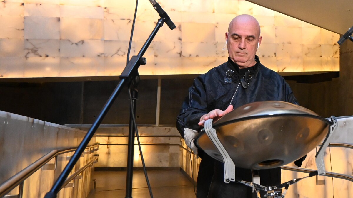 Un homme joue le handpan, un instrument à percussion en métal, qui ressemble à une soucoupe volante