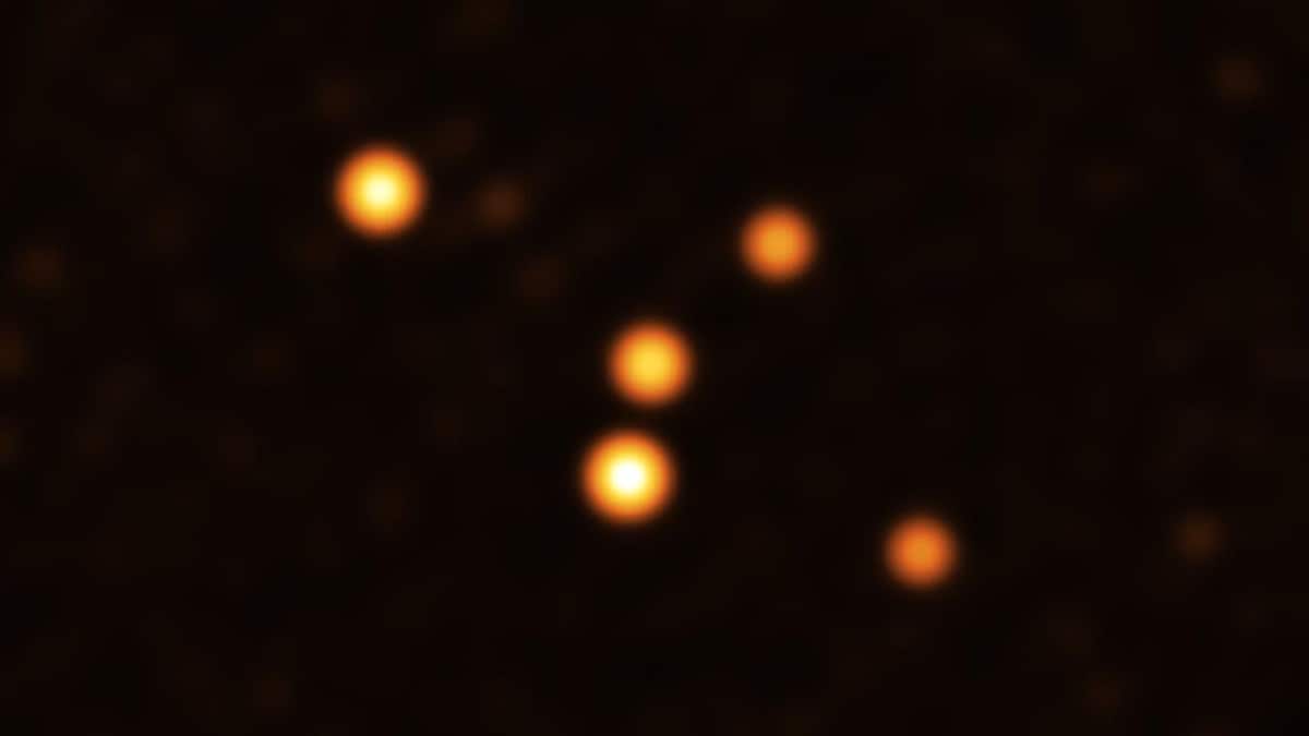 Cinq points orangés sur fond noir. L'image montre les étoiles en orbite très proche de Sgr A* (au centre), le trou noir supermassif au cœur de la Voie lactée.