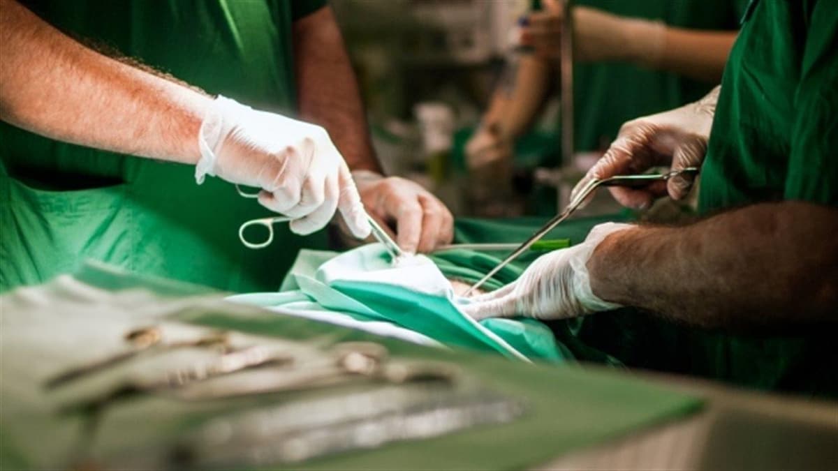 Une salle d'opération, on voit les mains des chirurgiens gantées en train d'opérer.