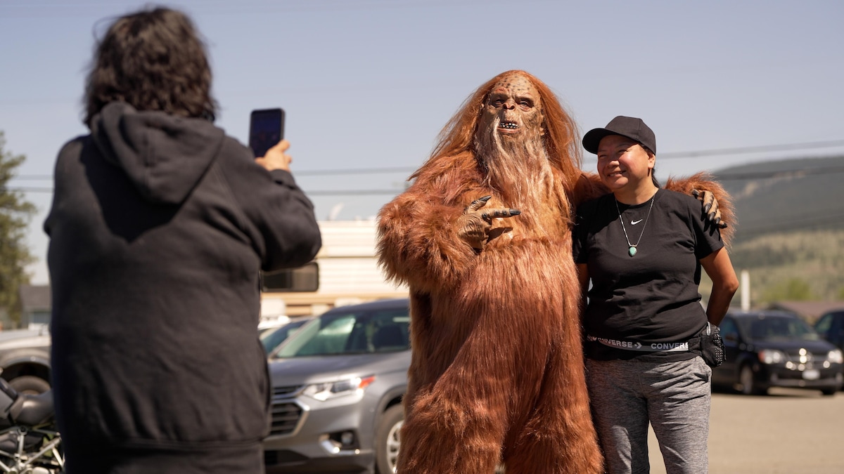 Un homme déguisé en Sasquatch pose avec des participants à la Nicola Valley Bigfoot Conference, en mai 2023.