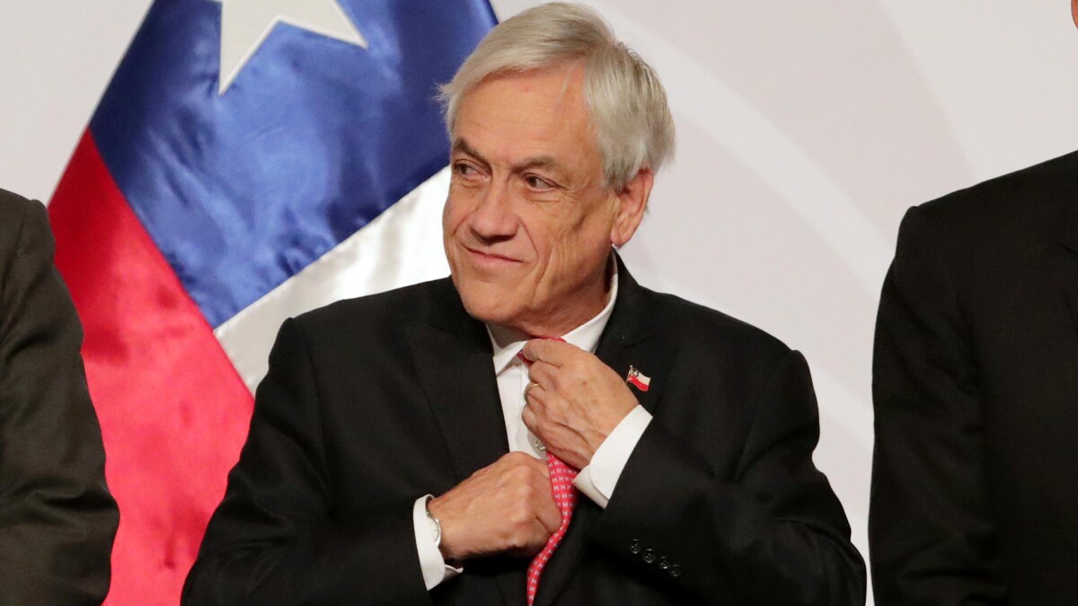 Sebastian Piñera ajuste sa cravate avant la prise d'une photo officielle lors d'une conférence internationale.