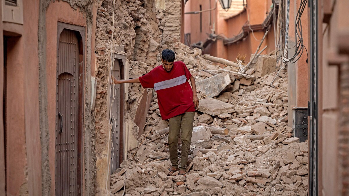 Un homme marche à travers les ruines.