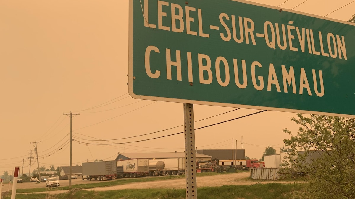 Une pancarte annonçant Lebel-sur-Quévillon et Chibougamau près de fils électrique.