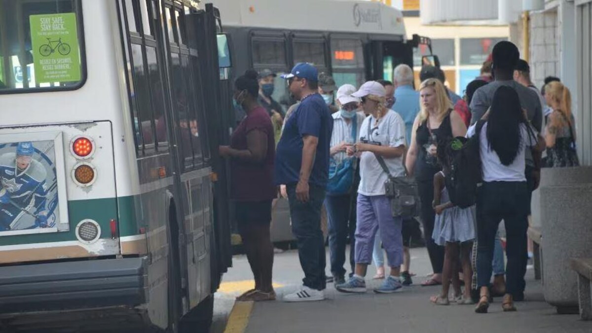 Des gens sont sur le point de monter à bord d'un autobus de transport en commun.
