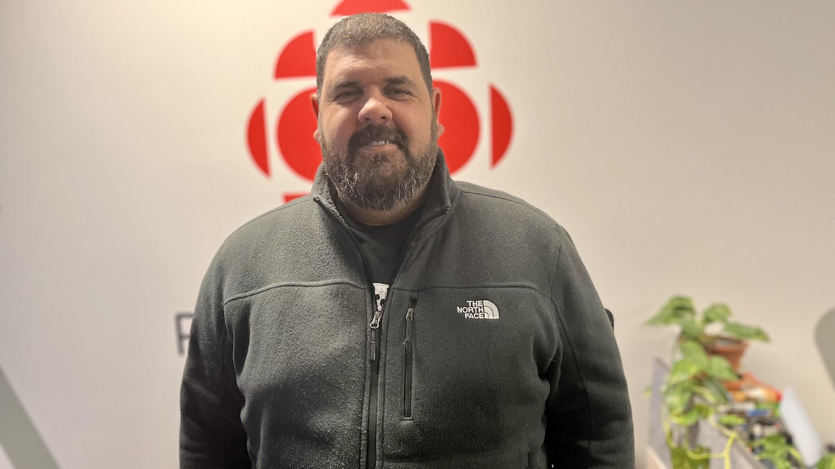 Shawn Smith pose pour la caméra en souriant dans les bureaux de Radio-Canada.