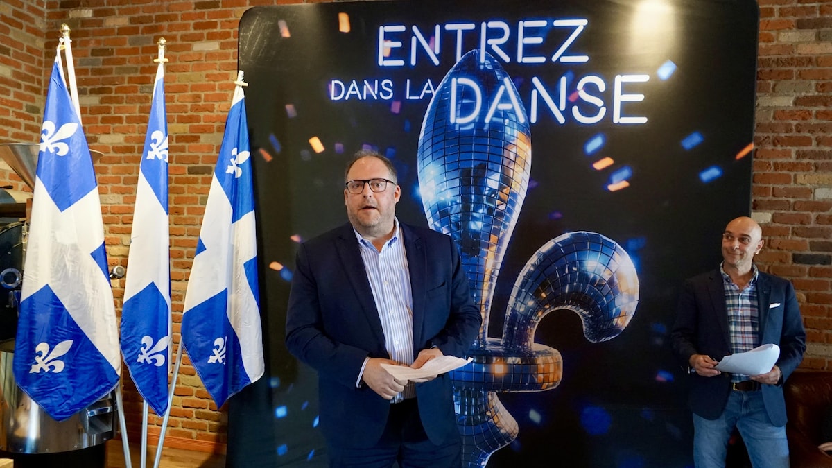 Simon Bissonnette devant un affiche où on peut lire: entrez dans la danse.                                