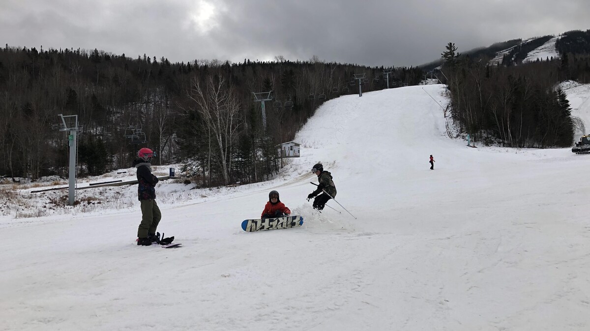 Trois jeunes skieurs dans une pente de ski.