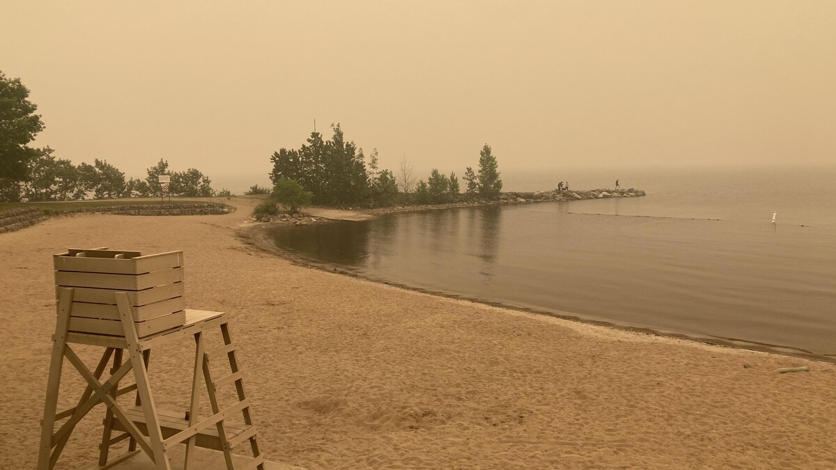 Le lac Saint-Jean avec un ciel jaune en raison du smog et une plage vide.