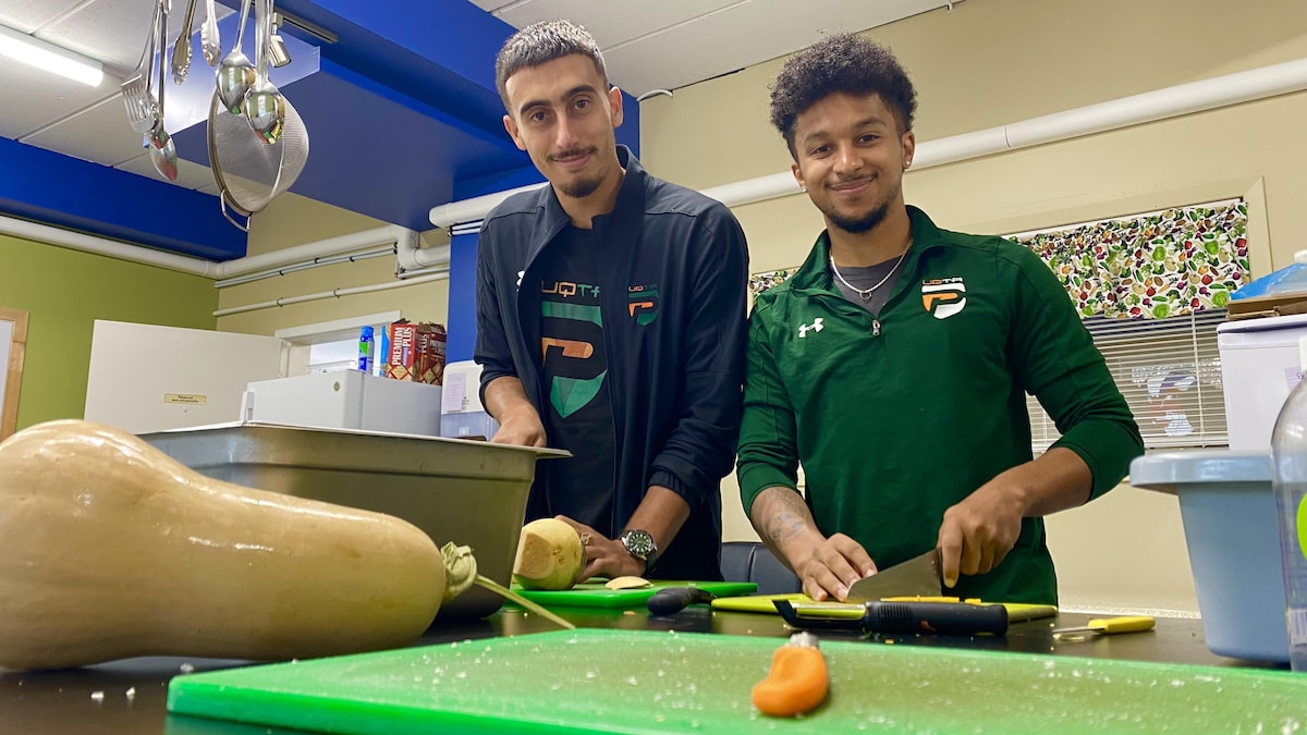 Madhi Abbassi et Samuel Laplante qui coupent des légumes.