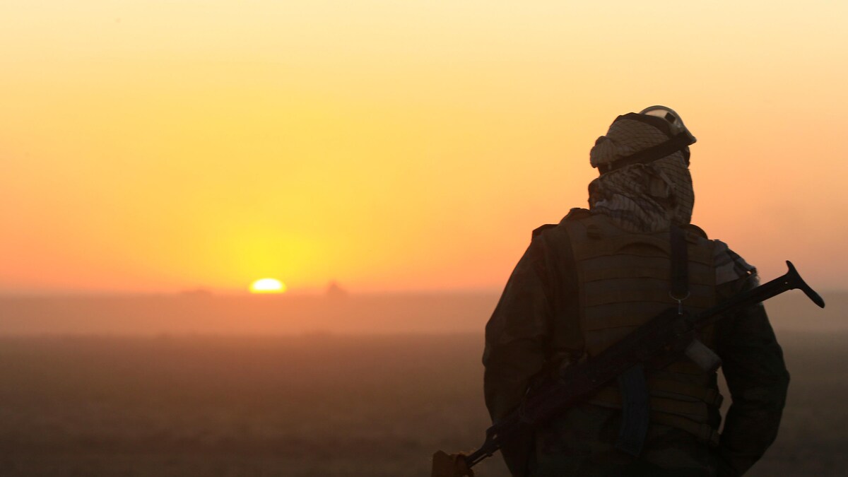Au coucher de soleil, un soldat chiite surveille l'horizon en vue d'une bataille contre le groupe armé État islamique, dans la ville irakienne de Tal Afar.