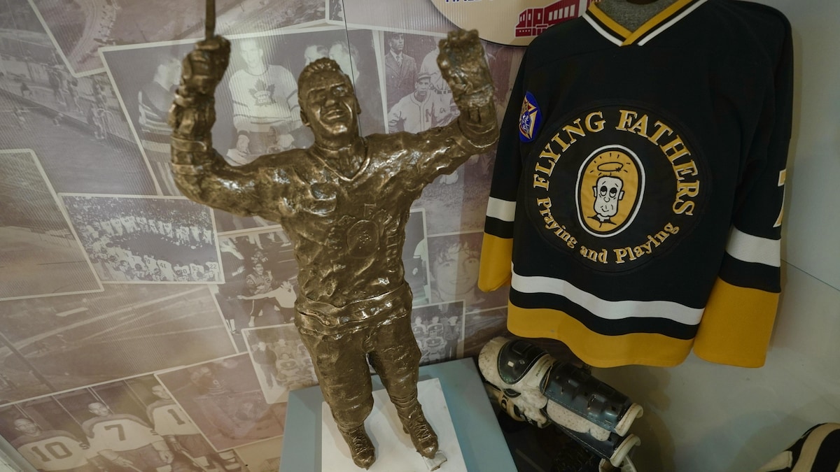 Une statue et un chandail de hockey des Flying Fathers.