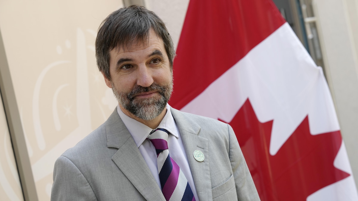 Portrait de Steven Guilbeault devant un drapeau canadien.
