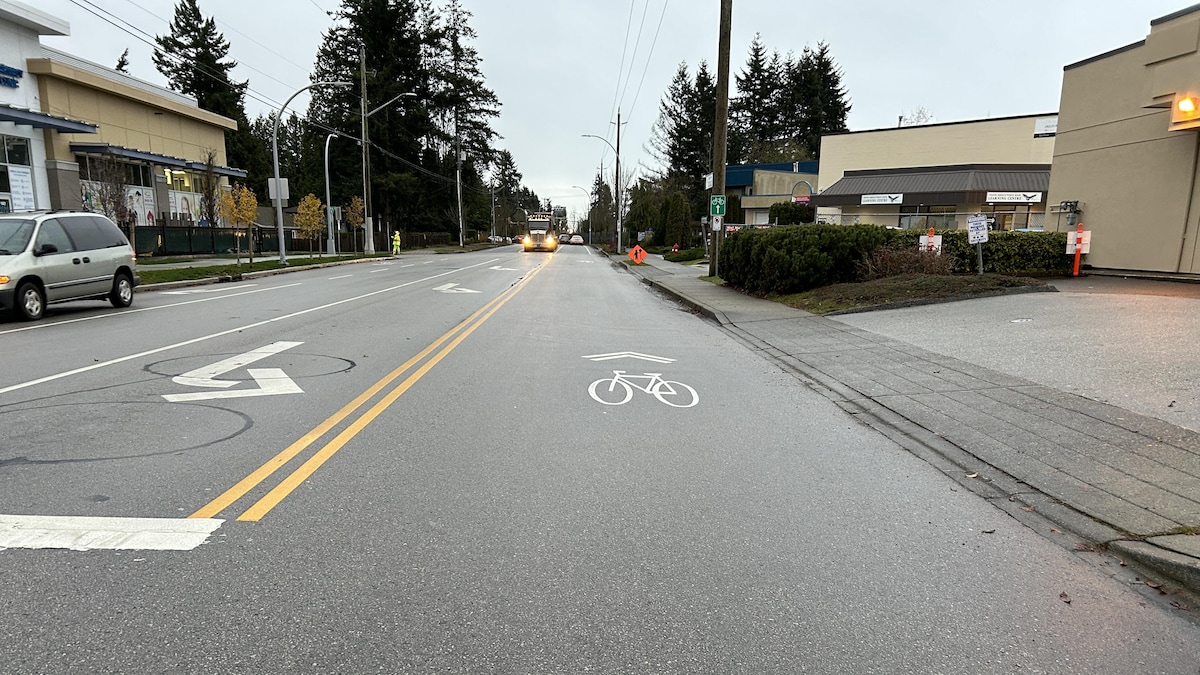 Une route sur laquelle un pictogramme de vélo est peint. Un camion à semi-remorque arrive à contresens. Photo prise le 4 décembre 2023.