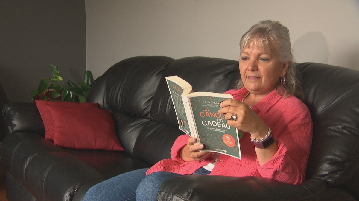 Lucie Lacombe, une survivante du cancer, lit un livre de motivation pour les personnes ayant vécu avec le cancer.
