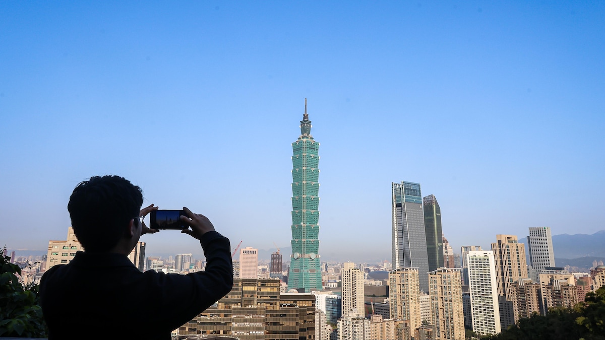 Un homme prend une photo de la mégalopole Taipei en janvier 2024.