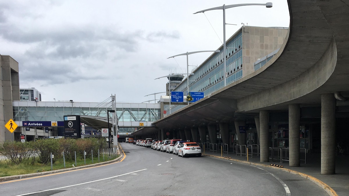 Des taxis stationnés devant l'aéroport de Montréal.