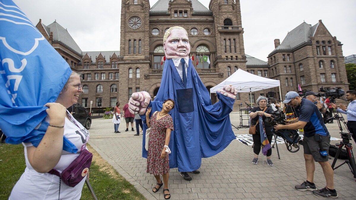 Des manifestants et des journalistes devant Queen's Park.