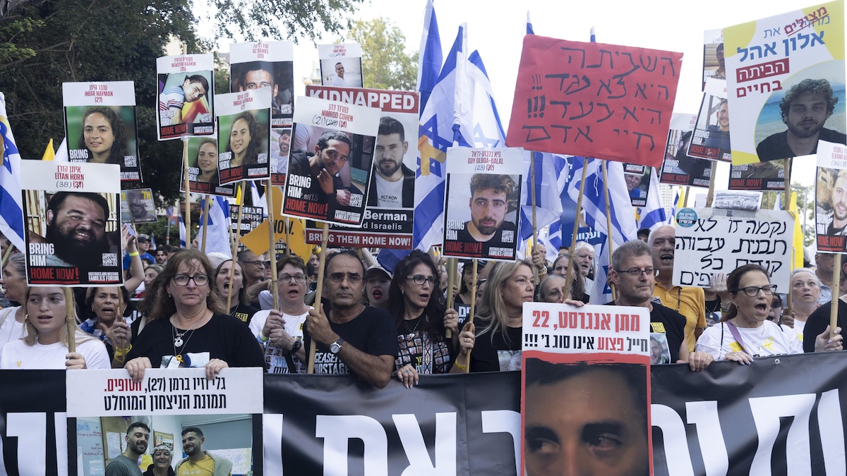 Les familles des otages et leurs sympathisants brandissent des photos des otages lors d'une manifestation appelant à un accord pour leur libération, le 17 août 2025 à Tel-Aviv.