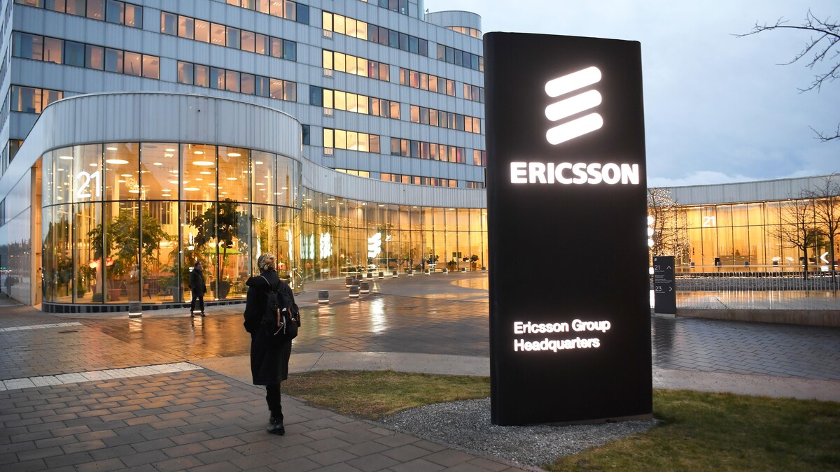 Une femme marche devant le siège social d'Ericsson.