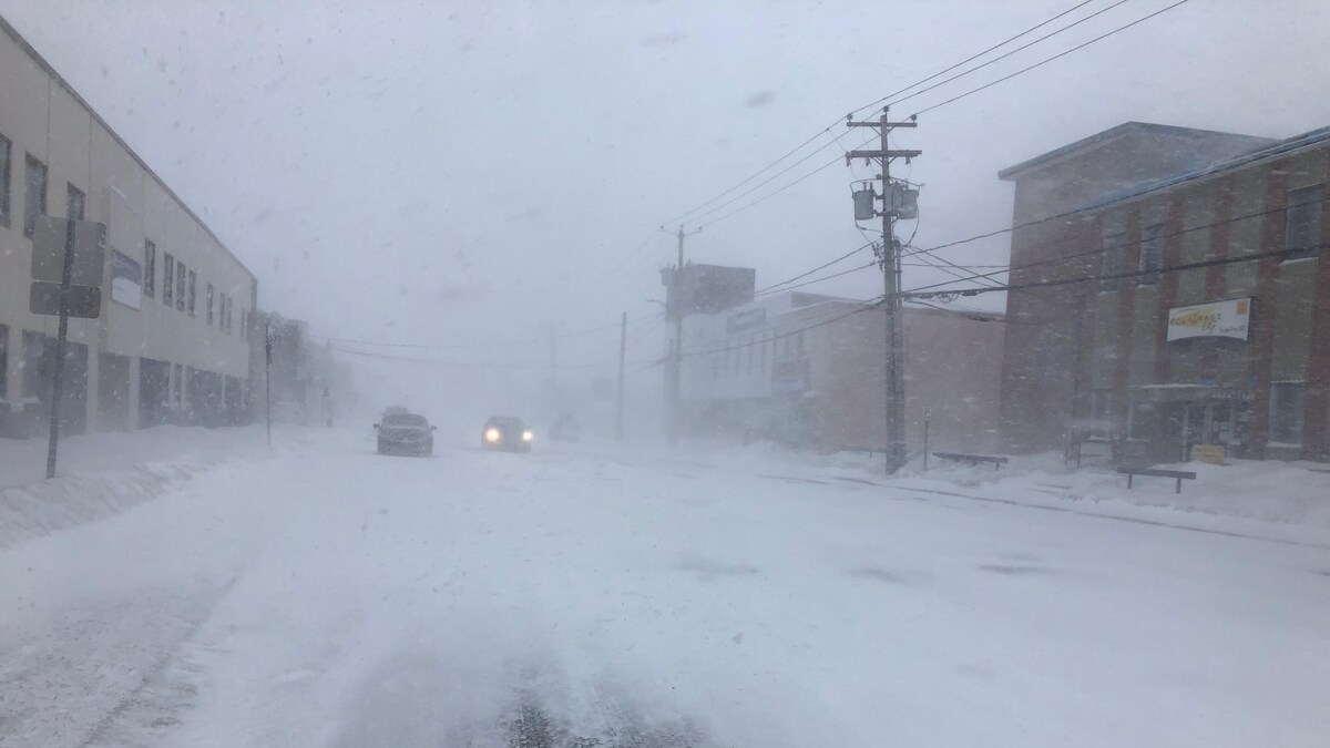 Une voiture roule sur la rue Brochu à Sept-Îles en pleine tempête de neige le 1er mars 2021.