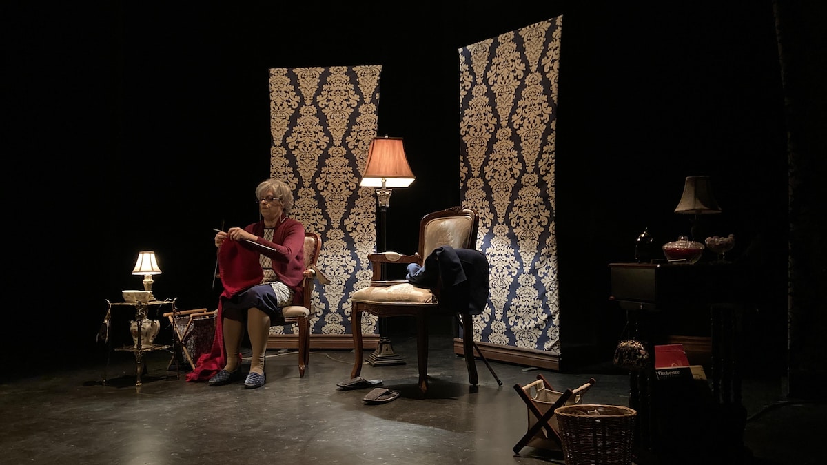 Un décor de théâtre avec une femme déguisée en personne âgée.