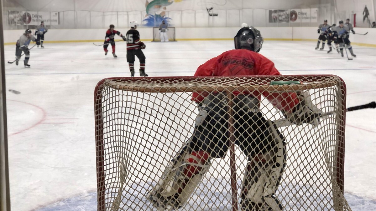 Filet et gardien de but durant une partie de hockey, le 16 décembre 2022, à Déline, aux Territoires du Nord-Ouest.