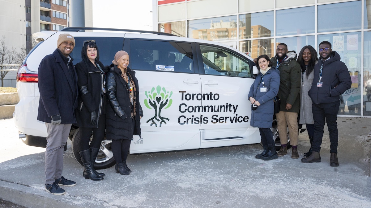 Un groupe pose devant une camionnette du programme Toronto Community Crisis Service