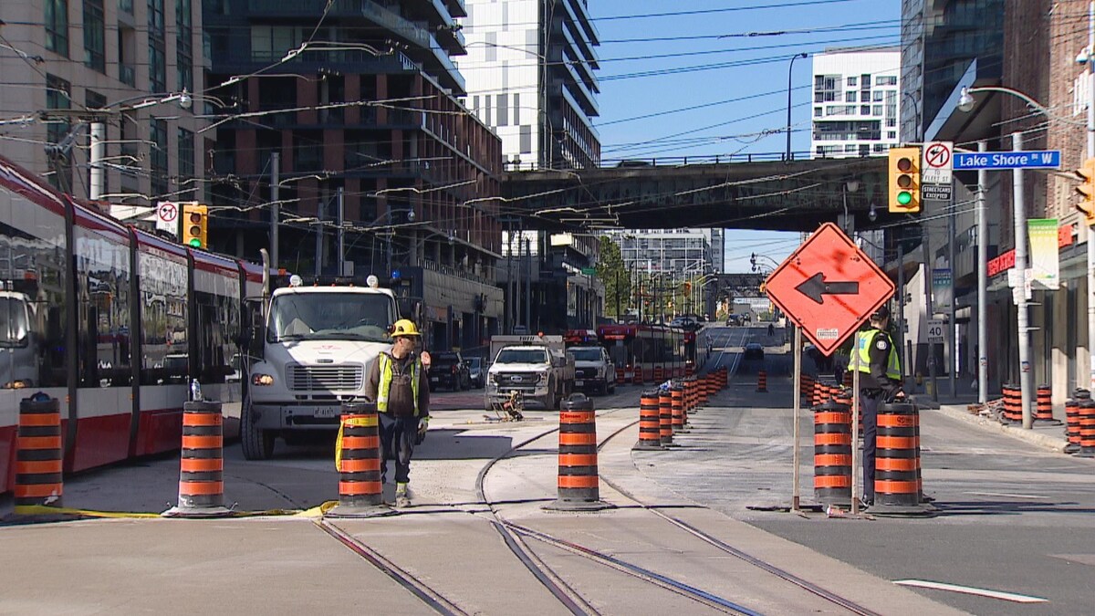 Un chantier de construction à l'intersection des rues Bathurst et Lakeshore Ouest. Des cônes sillonnent la rue et une voie de la rue Bathurst est fermée à la circulation.