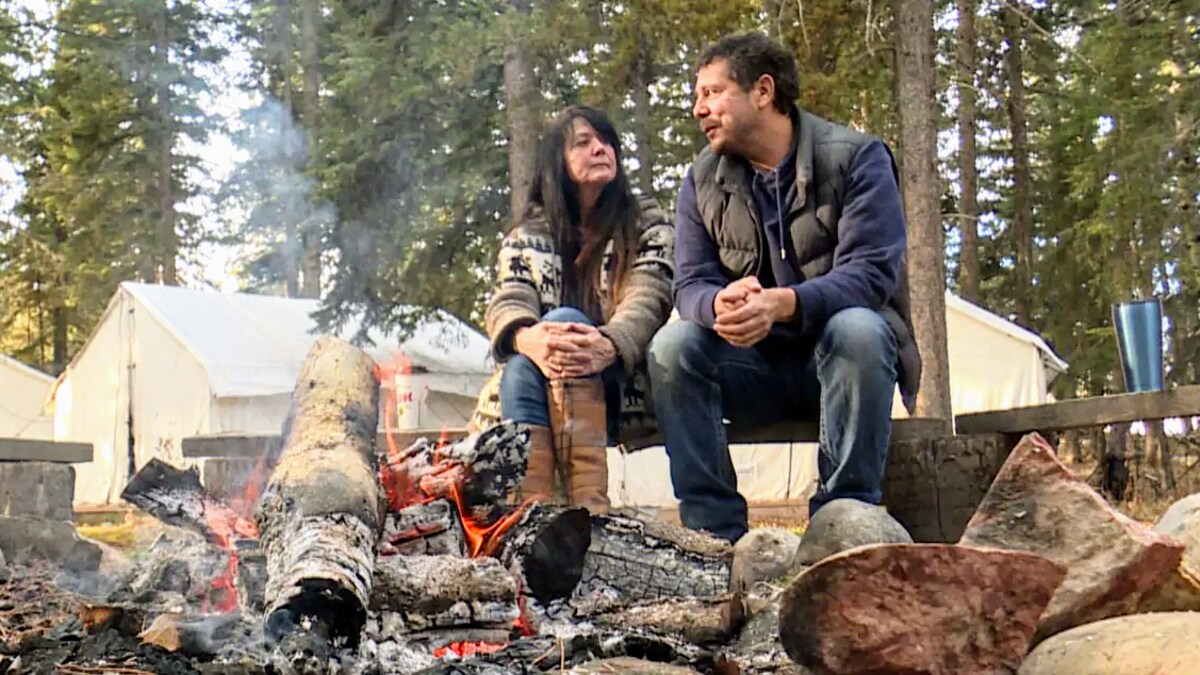 Tracey Klettl et Tim Mearns assis autour d'un feu de camps. 
