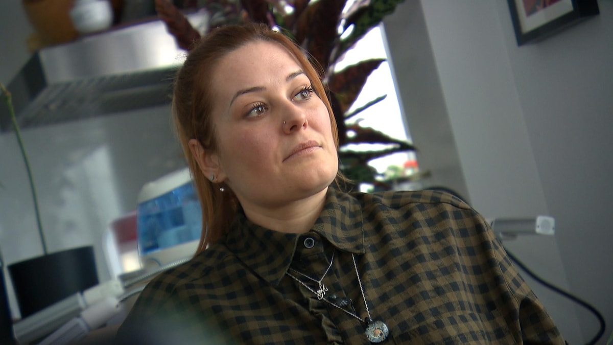 Une femme regarde dans le vide, l'air mélancolique. 