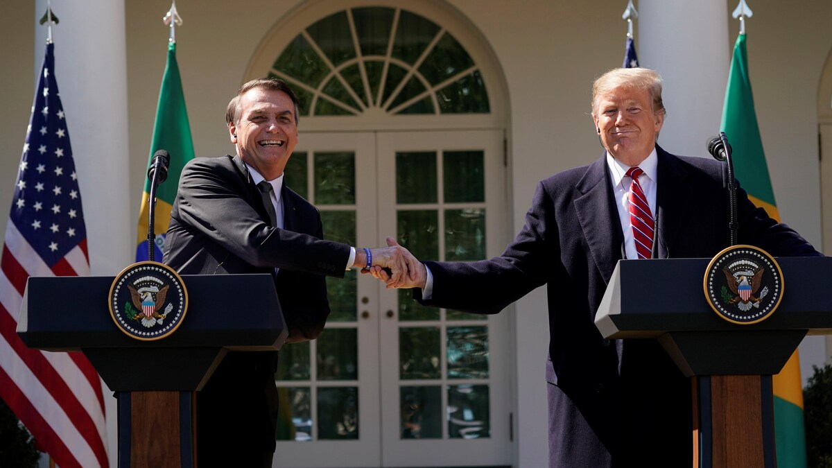 Tout sourire, Jair Bolsonaro et Donald Trump se serrent la main devant la Maison-Blanche.