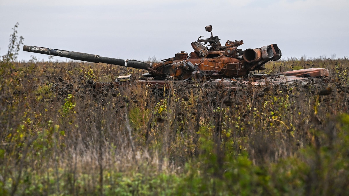 Un char d'assaut russe brûlé dans un champ de tournesols.