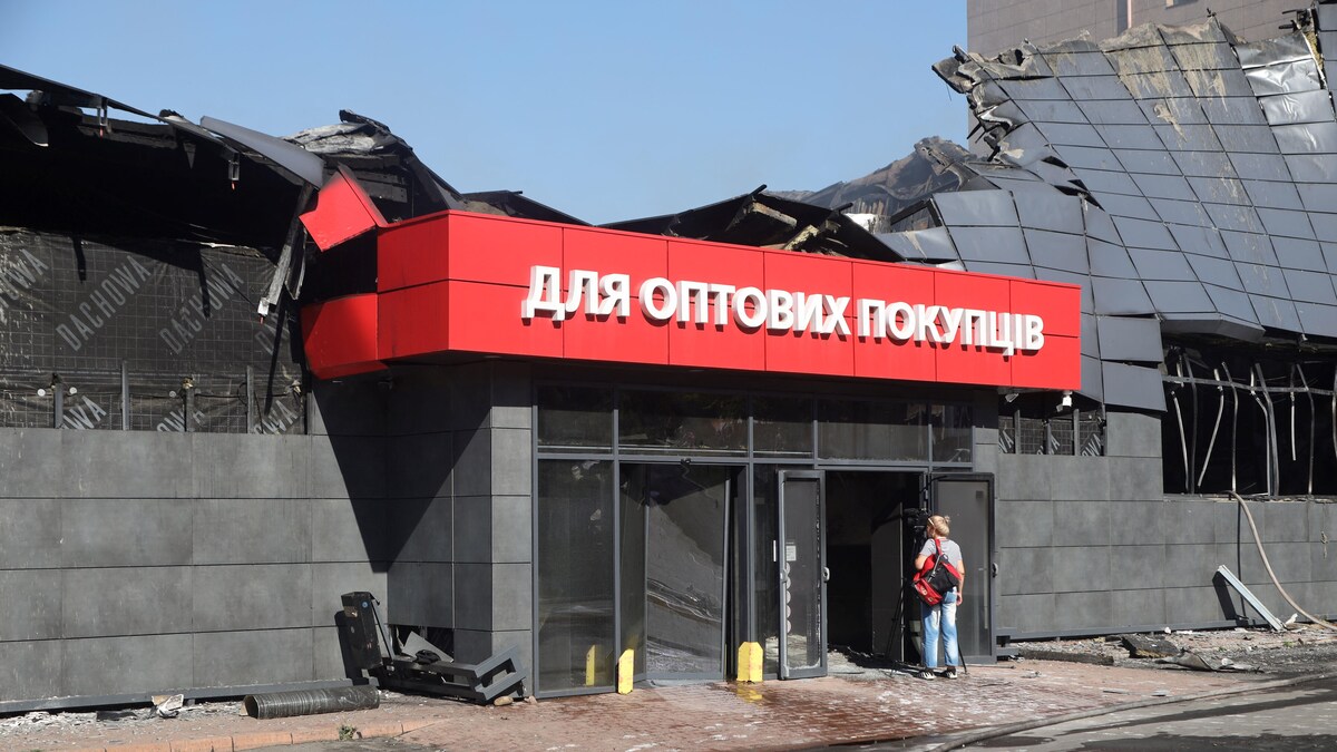 Une femme regarde l'intérieur d'un supermarché détruit par une attaque nocturne à Odessa.