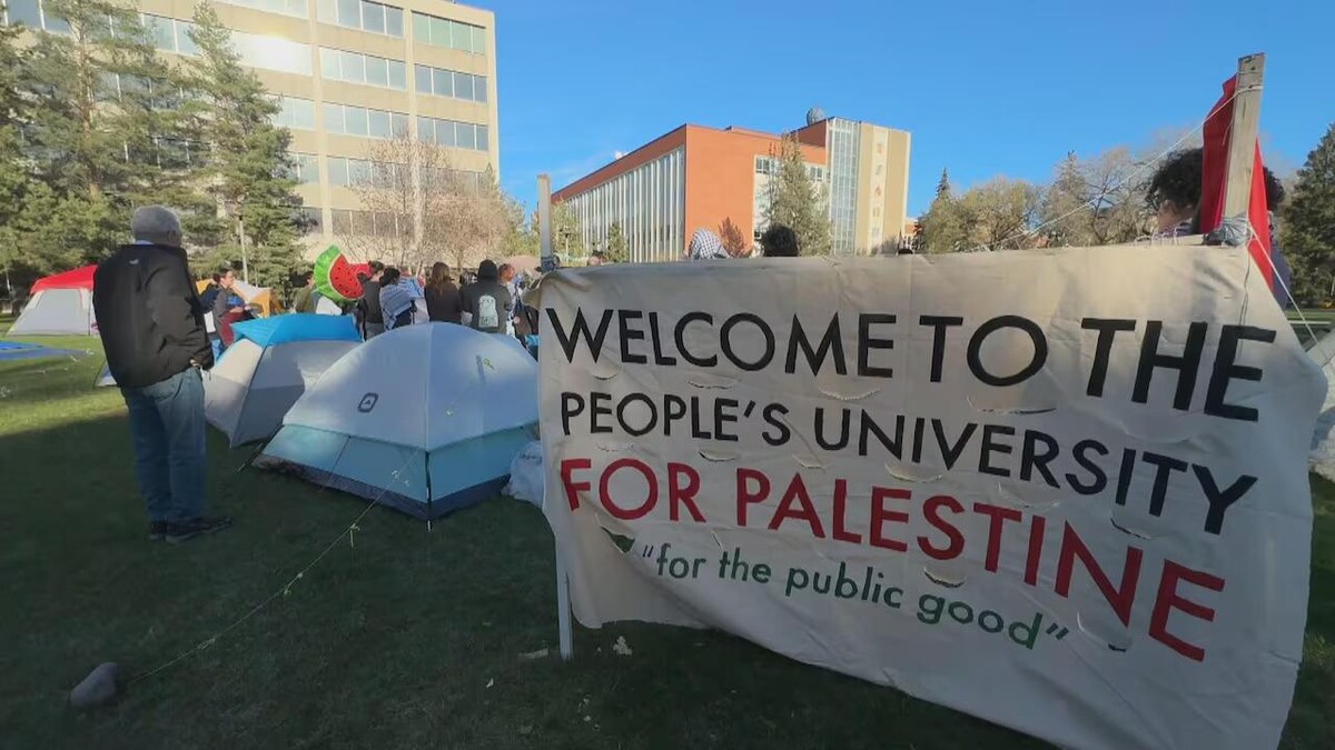 Des tentes sont plantées sur le campus de l'université. Sur une banderole on peut lire « Bienvenue à l'Université du peuple pour la Palestine ». Puis, « pour le bien public ».