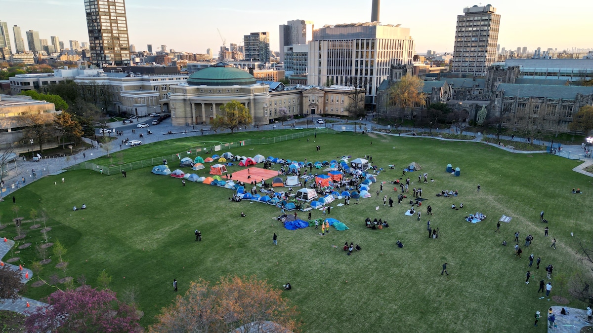 Plusieurs dizaines de tentes sont installées sur une grande pelouse dans uen ville. 