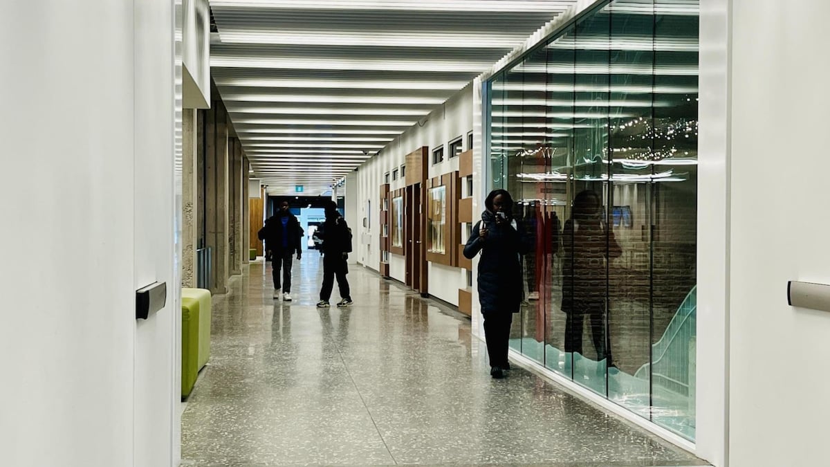 Des étudiants marchent dans un corridor.