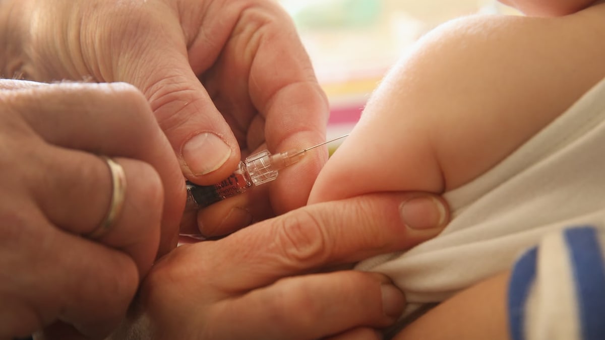 Un enfant est en train de recevoir une dose de vaccin.
