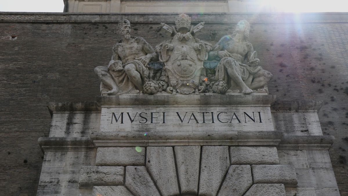 L'entrée du musée avec écrit, en italien, « Musée Vatican » et une sculpture.
