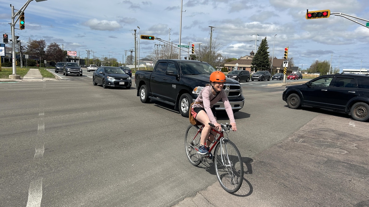 Un cycliste traverse une rue à Moncton.