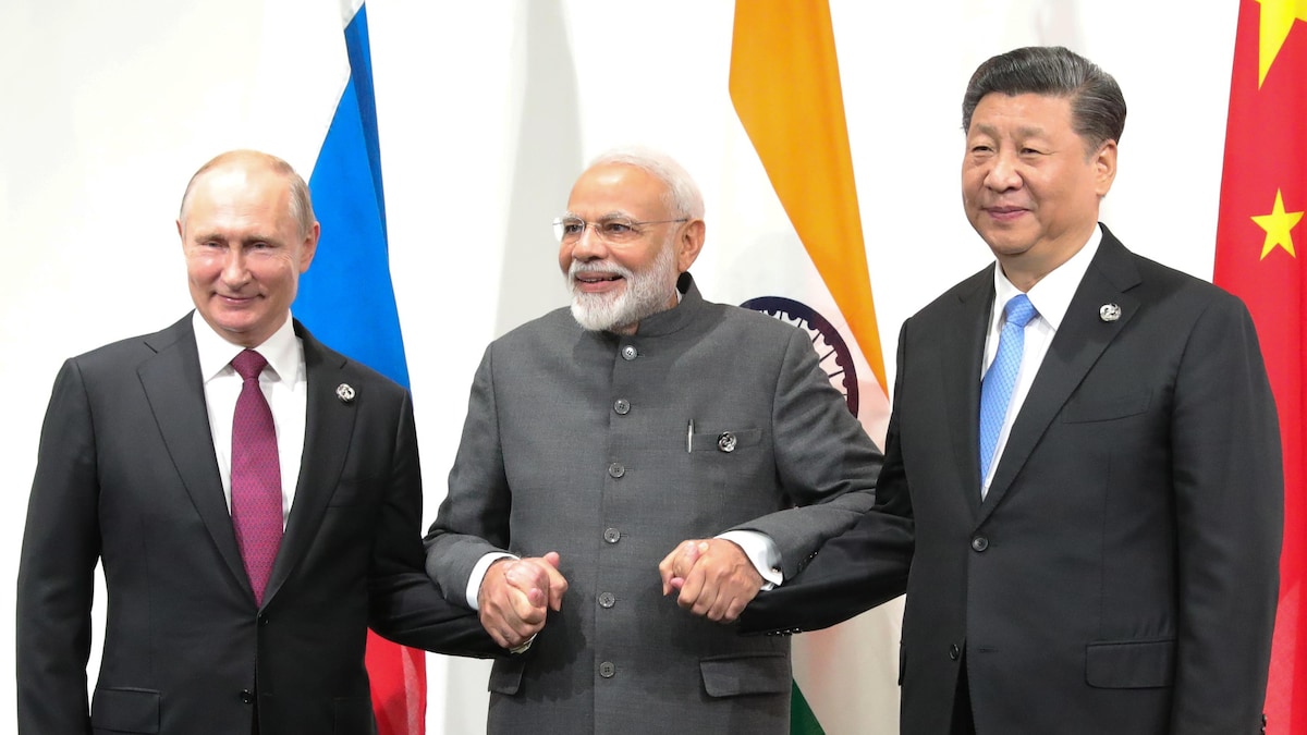 Le Premier ministre indien Narendra Modi, tenant la main du président russe Vladimir Poutine et du chef de l'État chinois Xi Jinping, lors du sommet du G20 de 2019 au Japon.