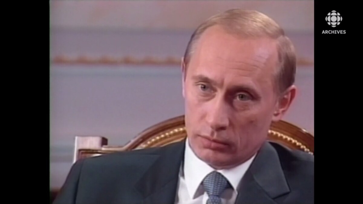 Vladimir Poutine, assis à un fauteuil du Kremlin, l'air sérieux.