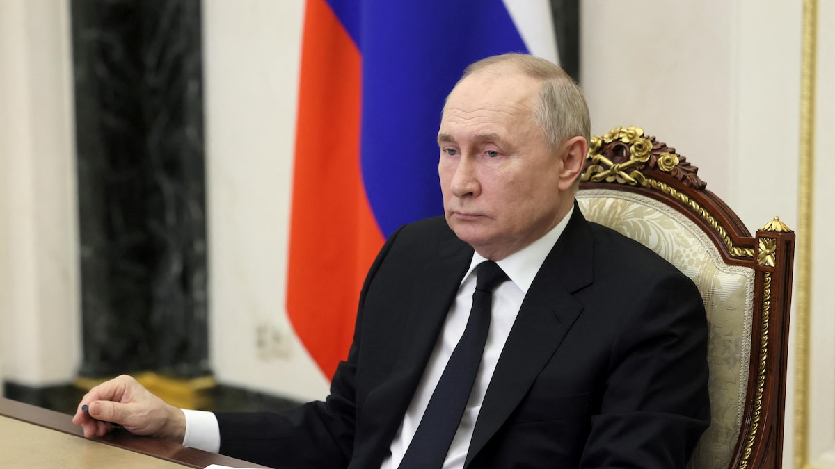 Poutine assis à son bureau.
