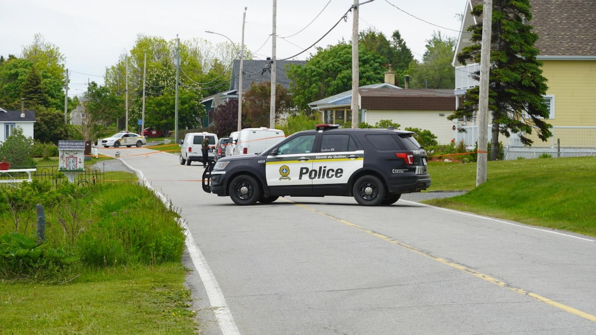 Un véhicule de la Sûreté du Québec barre la route dans une rue résidentielle.